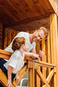 快乐的父亲和女儿一起花时间在木屋图片