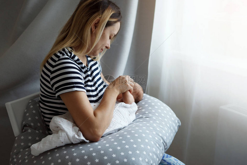一位年轻母亲正在母乳喂养她七天大的女儿图片