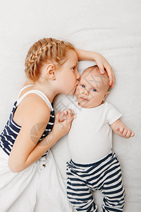 可爱的白人女孩妹抱着亲吻的小婴儿图片