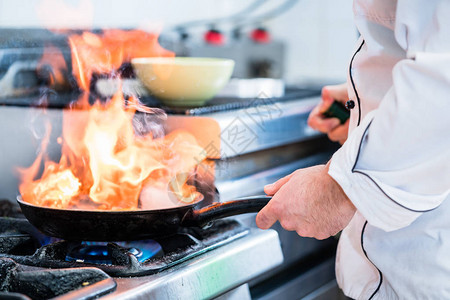 厨师用大火在锅里烧菜图片