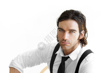 白色背景下一位身穿白衬衫黑色领带和吊带的时尚年图片