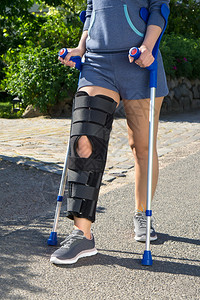 身穿双腿有可调整侧面板以固定和支撑膝盖的外科手术的妇女图片