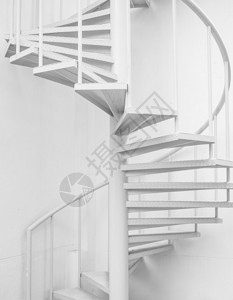 本底白钢螺旋楼梯和白墙图片