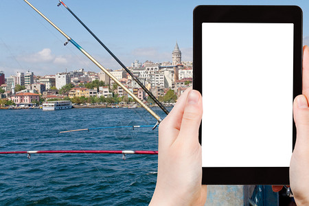 土耳其伊斯坦布尔加拉塔桥上的旅游照片渔民在平板电脑上图片