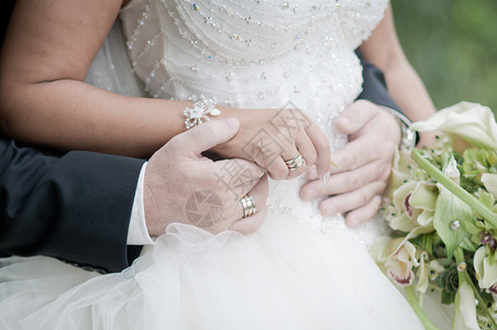 婚礼花束上的手和戒指图片