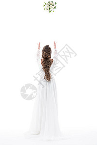白衣服新娘的背面扔着婚礼花束背景图片