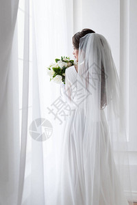 穿着传统面纱和花束礼服的婚纱中的图片