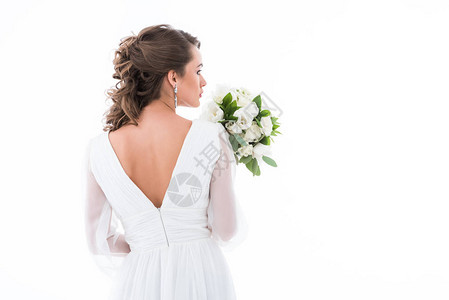 穿着白色礼服的新娘背着白衣拿着婚礼花束图片