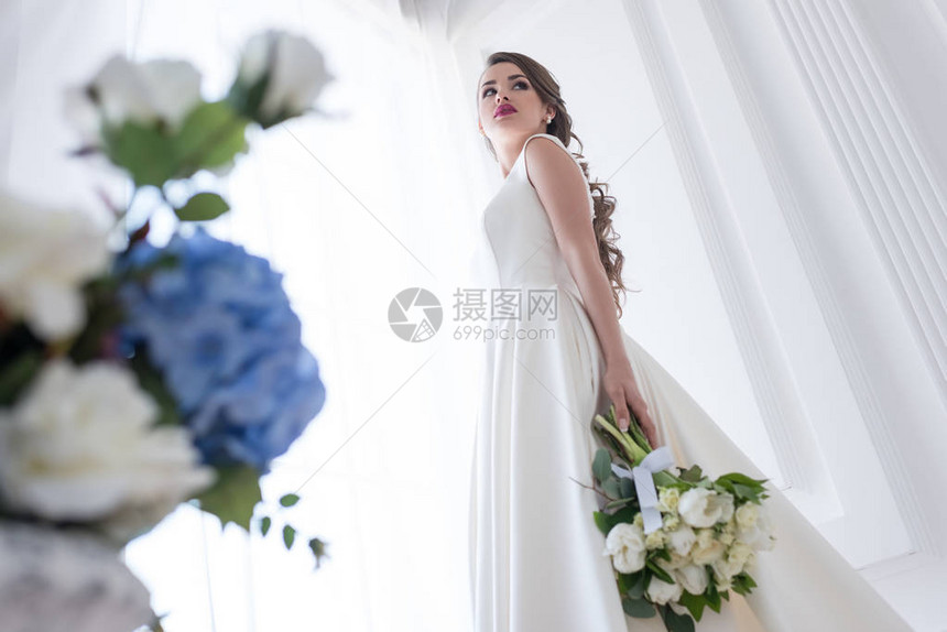 穿着白色礼服和婚礼花束装扮新图片