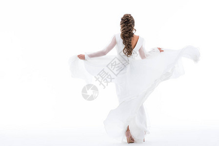 传统婚纱中优雅的新娘舞蹈的背面景象在背景图片
