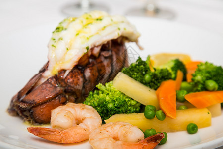 龙虾尾虾和蔬菜的海鲜晚餐图片