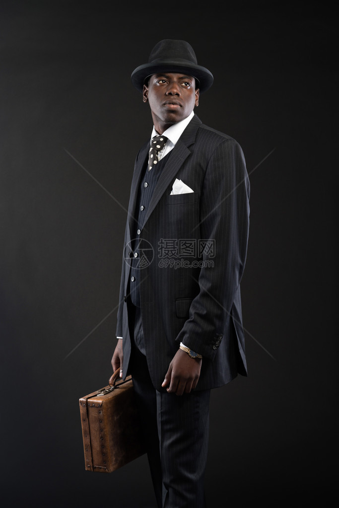 身穿条纹西装领带和黑帽子的非洲商人图片