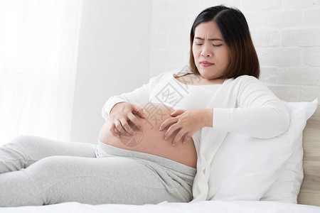 东南亚的怀孕妇女因刺伤皮肤腹部而痛痒图片