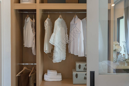 现代衣橱衣服挂在铁轨上白色木制衣柜图片