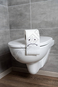 浴室陶瓷马桶上卫生纸上的悲伤表情图片