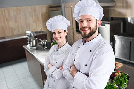 男女厨师专业团队在厨房用折臂站图片