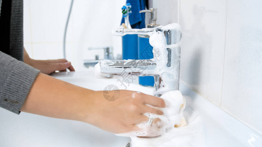 女洗手水槽龙头与洗涤剂的特写图像图片
