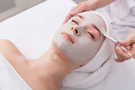 面部脱皮面膜水疗美容护肤女人在水疗沙龙接受美容师的面部护理图片