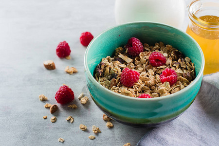健康早餐含坚果和草莓牛奶和蜂蜜以及白混凝土背景的燕麦颗图片