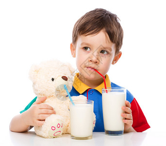可爱的小男孩喝牛奶用饮稻草孤图片
