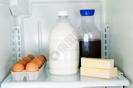 冰箱内玻璃架上牛奶鸡蛋黄油和果图片