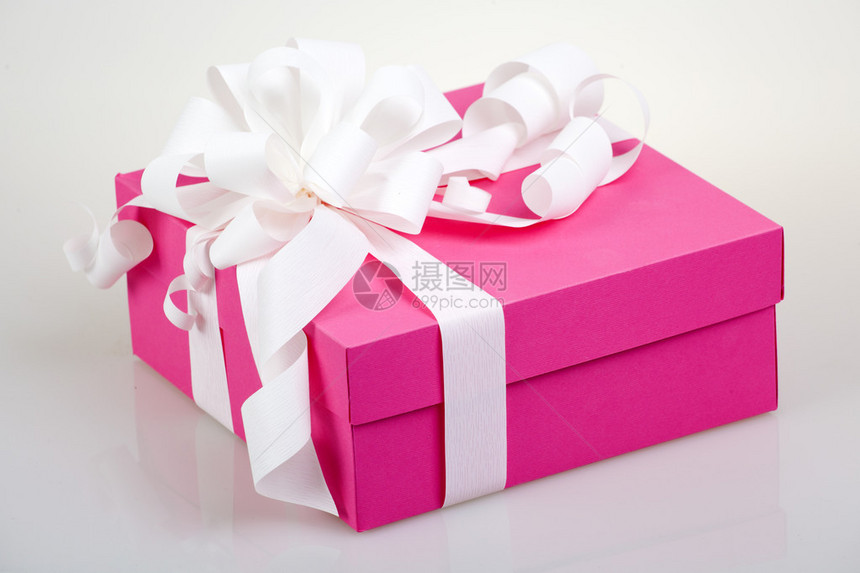 带白色丝带和蝴蝶结的粉色礼盒图片