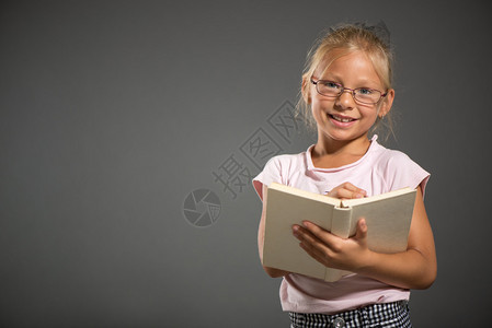 可爱的小女孩笑着装扮成书工作室关图片