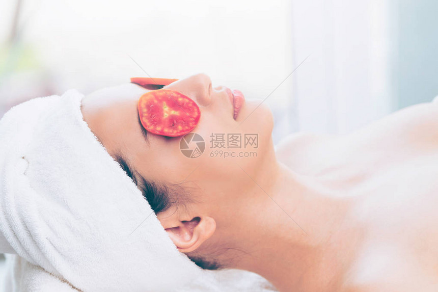 放松的年轻妇女在豪华温泉度假胜地接受西红柿对眼睛自然的治疗健图片