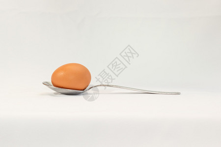 白色背景中勺子里的鸡蛋图片
