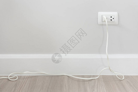 白墙上带电插头线的插座头室内设计背景
