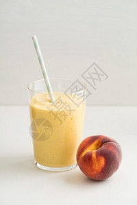 健康的橙色早餐冰沙配酸奶和玻璃杯中的桃子图片
