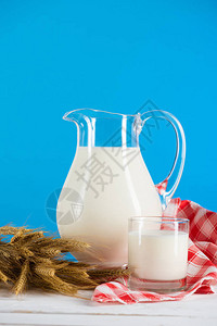 玻璃和罐子中新鲜有机牛奶与小麦图片