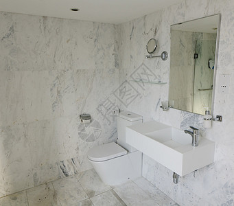 现代浴室配有镜子化妆镜马桶和浅色大理图片