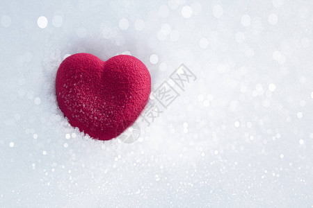 在波光粼的雪中的红心情人节的概念爱情幸福和奉献的象征顶视背景图片