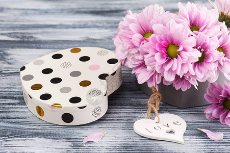 礼盒中的粉色菊花木质背景中的心图片