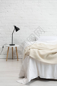 卧室有空的白色床和凳子上的灯图片