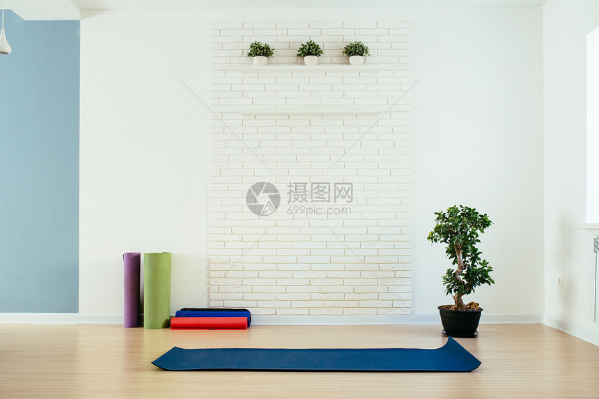 带垫子和白砖墙的瑜伽室图片