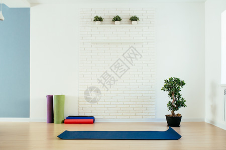 带垫子和白砖墙的瑜伽室图片