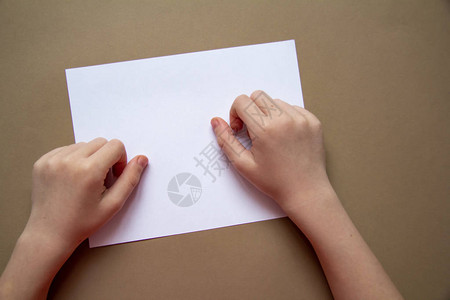 有鼻孔或胎记的孩子的手在纸工艺纸图片