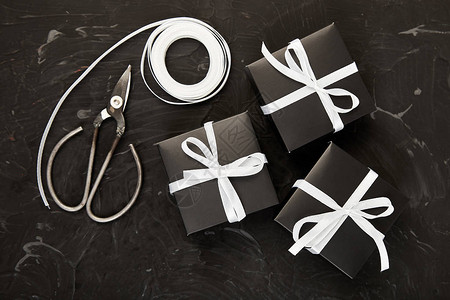 包装现代圣诞节或生日礼物在黑白颜色的礼物盒平躺图片
