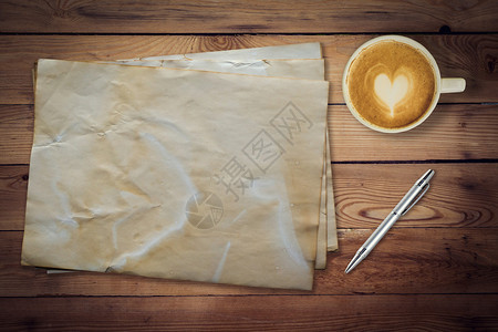 木桌纹理上的旧纸和咖啡背景图片