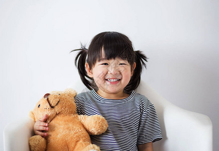 可爱又纯洁的亚洲孩子带着泰迪图片
