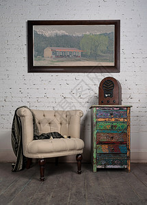 古老的米黄色手椅彩色橱柜老旧木制收音机和挂图片