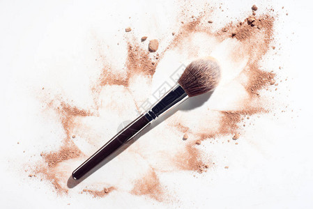 白色背景的毛绒化妆刷散面粉背景图片