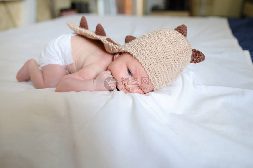 新出生的男孩穿着有趣的棕色毛线龙装图片