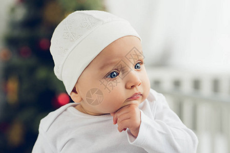 穿着白帽子可爱小宝的近身肖像上的圣图片
