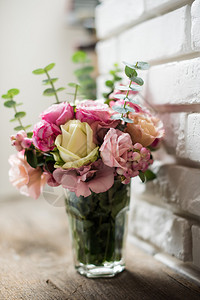 白色砖墙背景的粉红色和白玫瑰花束美丽的花束图片