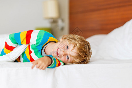 可爱的男孩睡在白床上睡觉后放松和休息图片