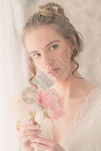 紧贴近一个美丽的年轻女士的肖像与尼斯发丝风格持有一包新鲜花同时背景图片