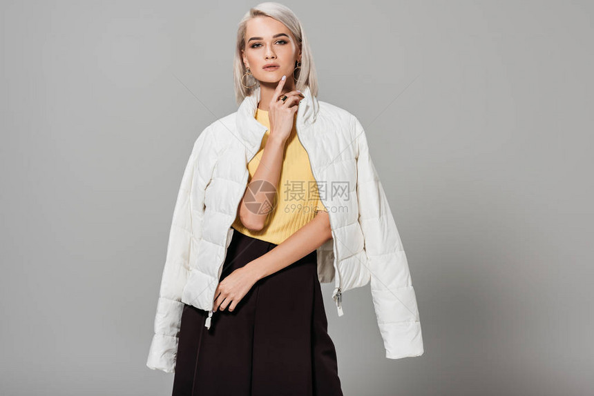 身穿白外套的自信年轻女模特图片